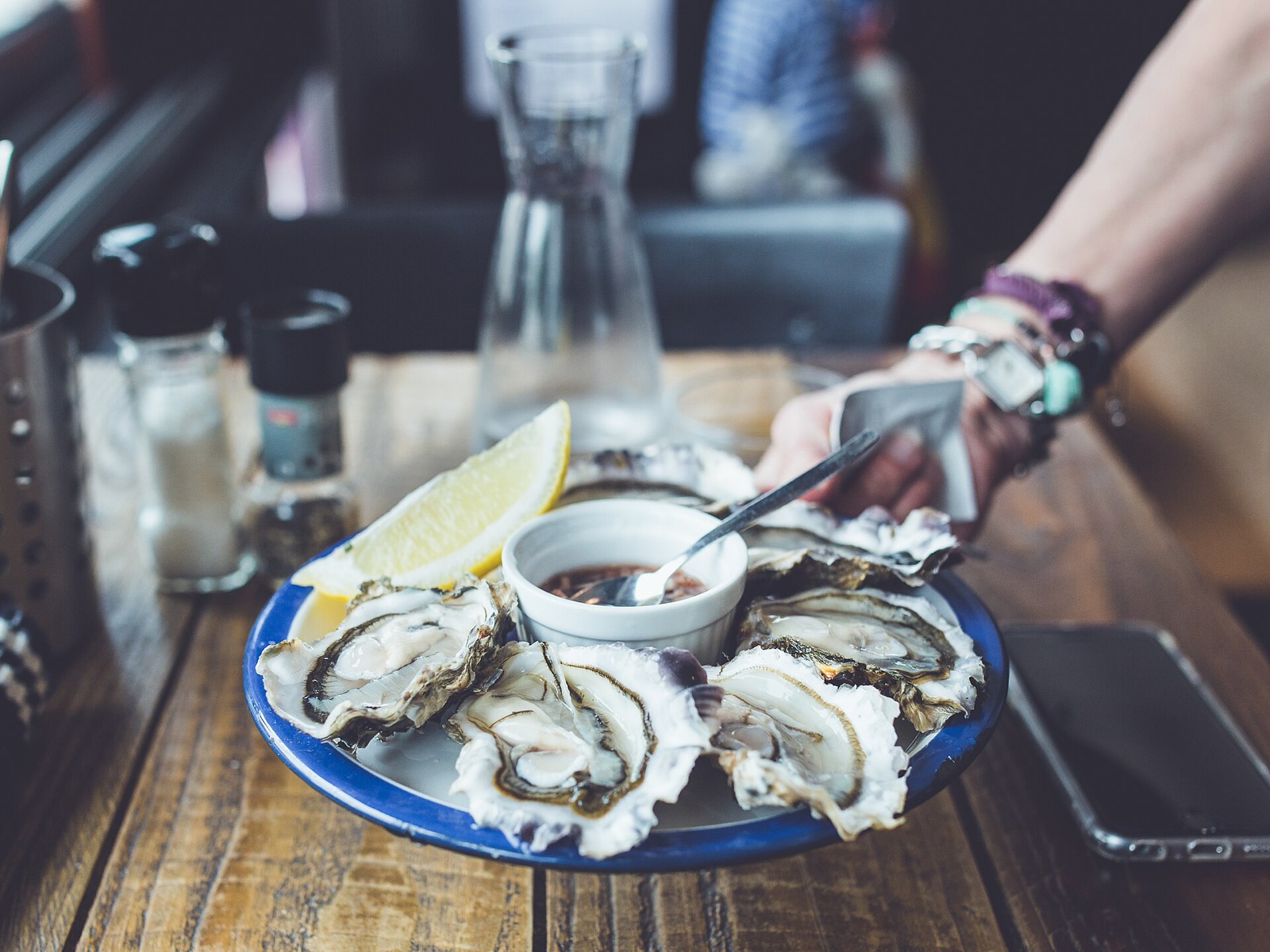 A plate of fresh oysters on the half shell with lemon and mignonette